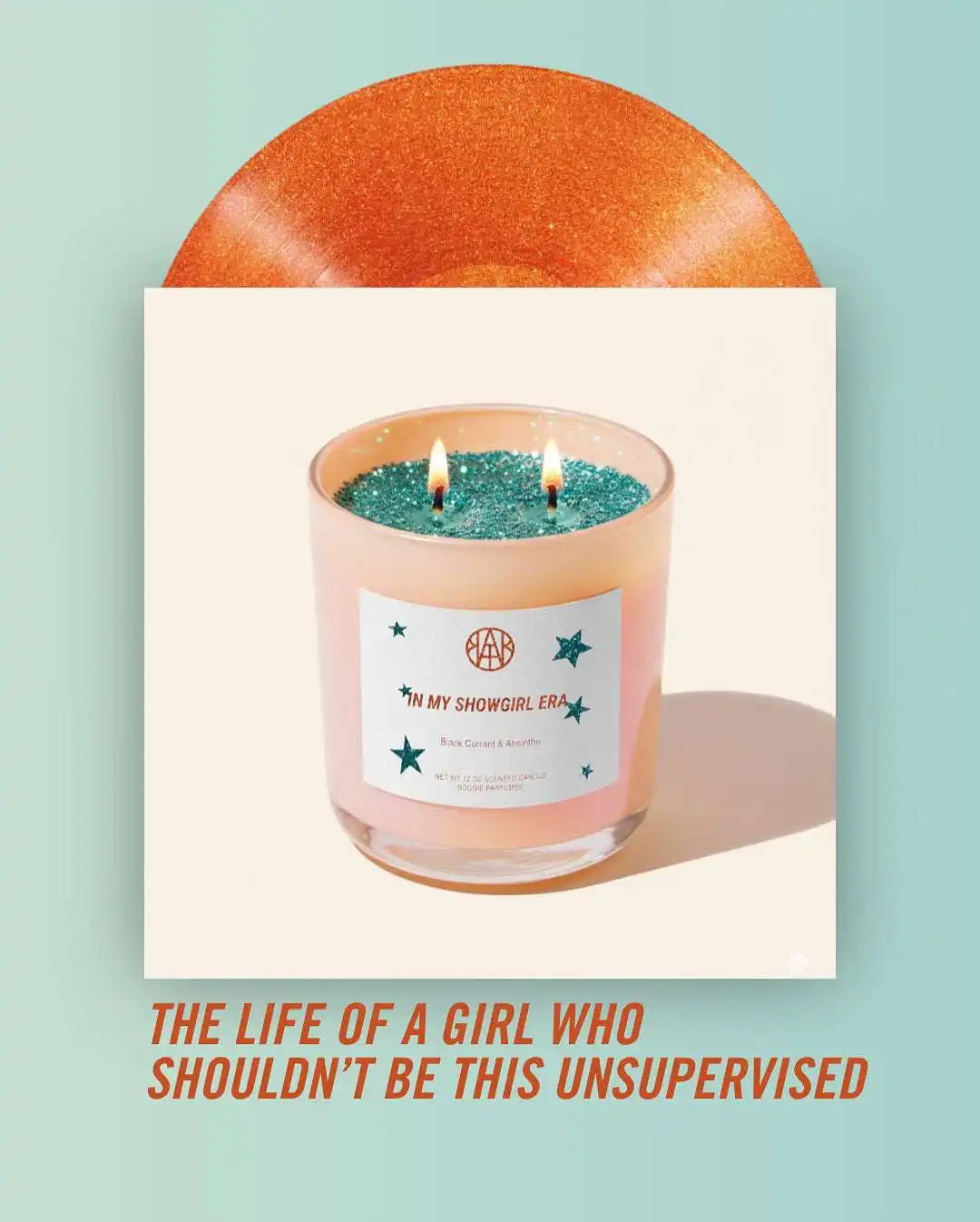 AEMBR non-toxic glitter candle with blue wax, front label, and decorative stars, on pastel background