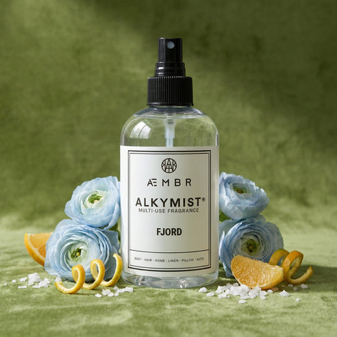 Aembr Alkymist multi-use fragrance bottle with flowers and oranges on a green background