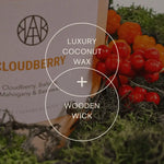AEMBR Cloudberry luxury coconut wax candle with wooden wick, surrounded by berries and moss.