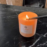 Lighting an AEMBR Gloamberry non-toxic candle on a dark marble tabletop