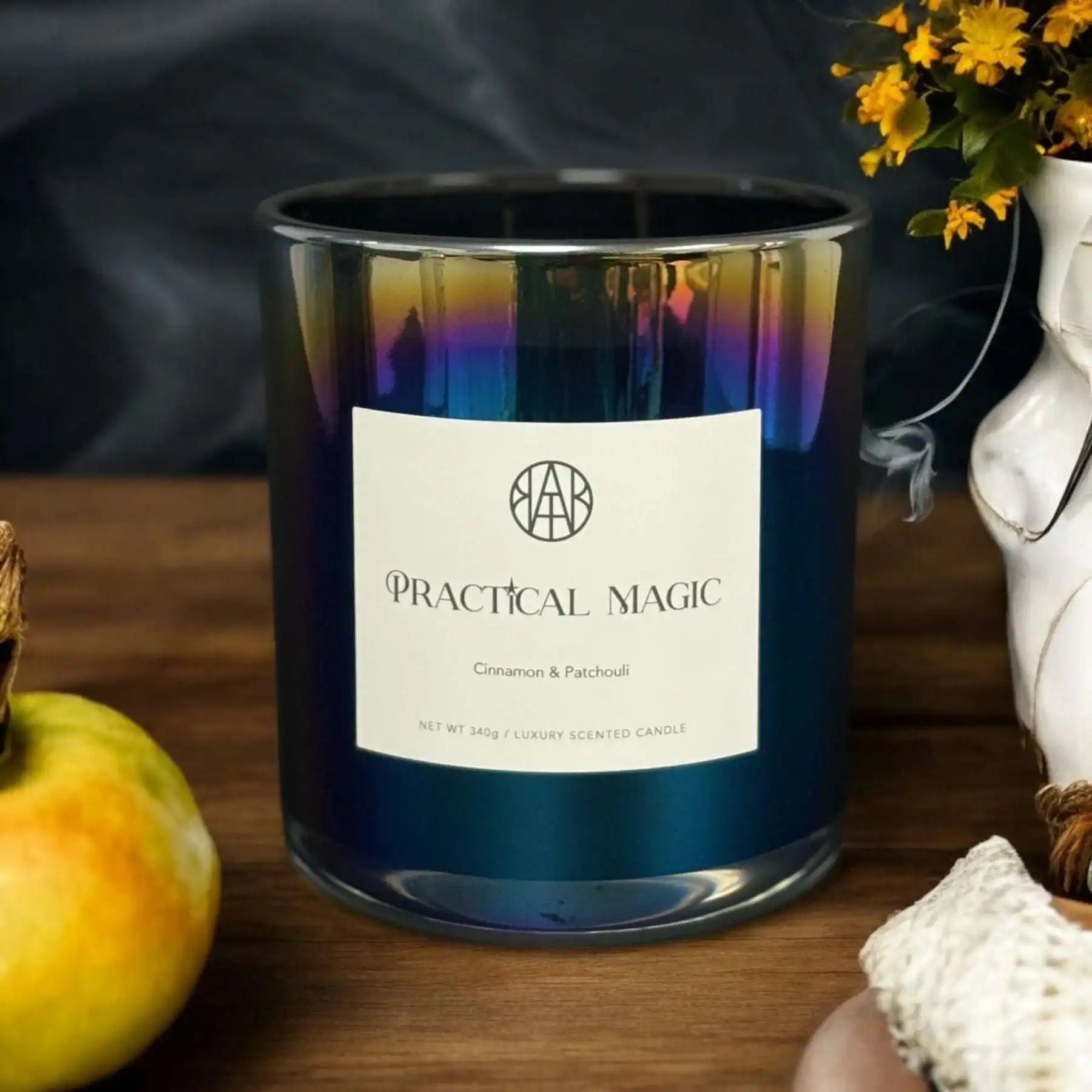 AEMBR Practical Magic cinnamon and patchouli luxury candle in iridescent glass on wooden table