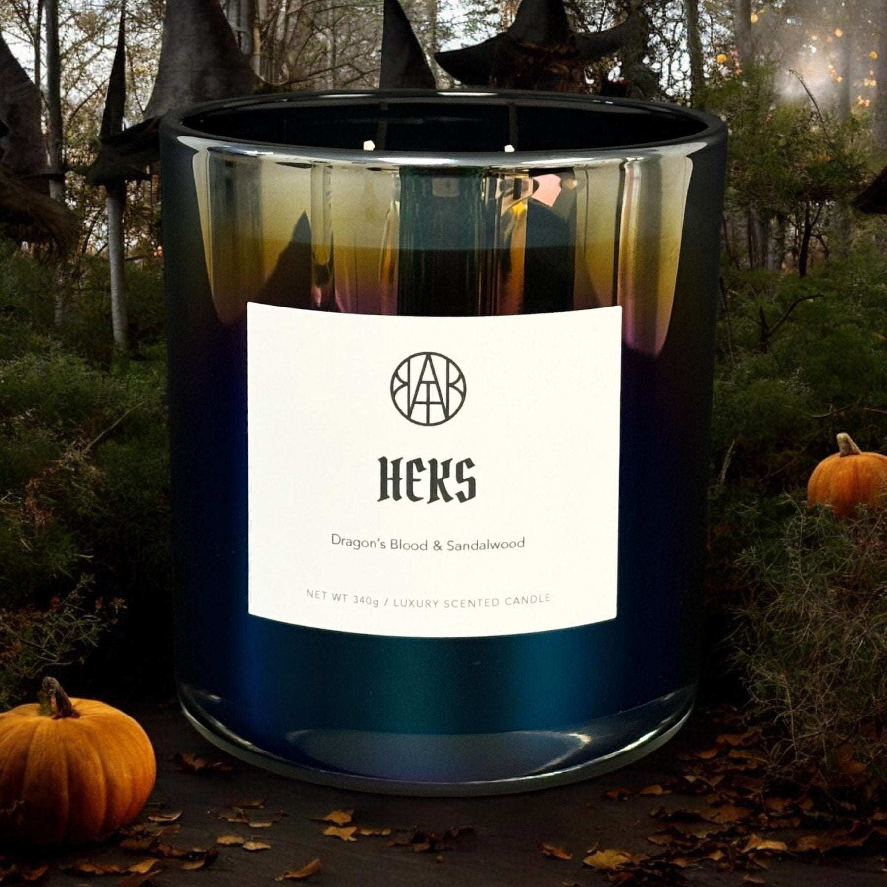 AEMBR HEKS luxury scented candle with Dragon's Blood & Sandalwood, outdoors with pumpkins