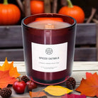 AEMBR Spiced Oatmilk candle in glass jar with autumn leaves, pumpkins, and seasonal decor