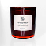 AEMBR Spiced Oatmilk scented candle in amber glass with cinnamon, oatmilk, and brown sugar label