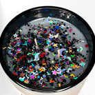 AEMBR non-toxic candle with colorful glitter, stars, and moons on the wax surface