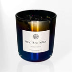 AEMBR Practical Magic cinnamon and patchouli scented candle in a glossy black glass jar.