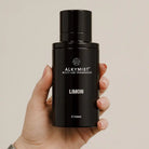 AEMBR ALKYMI8T Limon multi-use fragrance bottle held in hand against neutral background