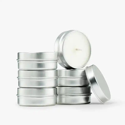 Stack of non-toxic travel candles in silver tins, minimalist design, clean background