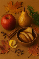 AEMBR autumn display with apple, pear, cinnamon sticks, cloves, lemon peel, and fall leaves on brown background.