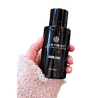 Hand holding AEMBR ALKYMI8T Vanilluxe multi-use fragrance bottle, non-toxic home scent