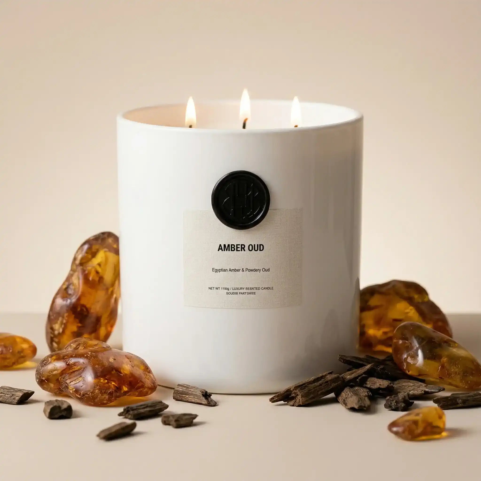 AEMBR Amber Oud luxury candle in white jar with amber stones and oud wood pieces