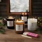 AEMBR non-toxic candles holiday bundle on rustic table with pine and matches, cozy winter setting