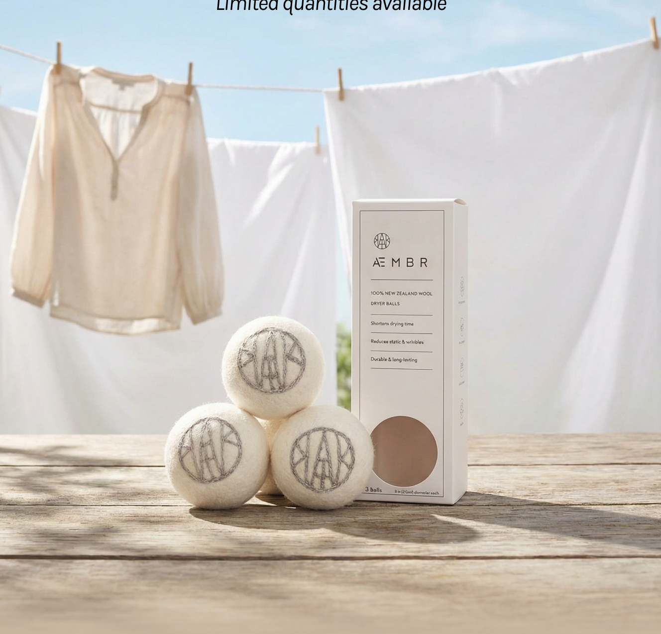Non-toxic wool dryer balls with packaging on outdoor table, laundry hanging in background
