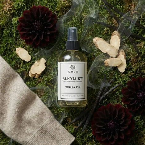 Non-toxic Vanilla Ash fragrance spray bottle on moss with flowers and vanilla pods
