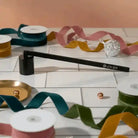 AEMBR candle snuffer with a sleek metal design for safely extinguishing candles.