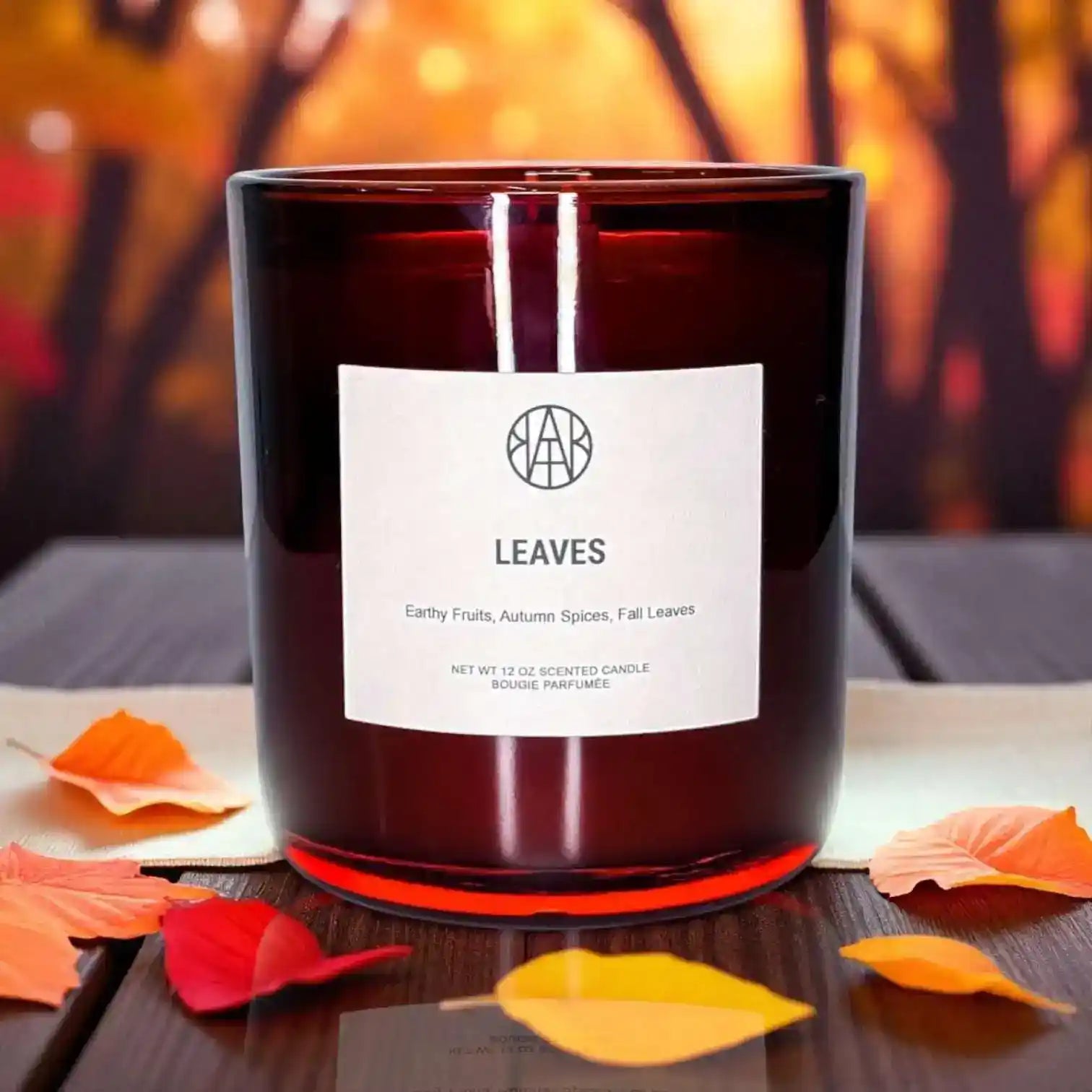 Non-toxic autumn scented candle in red glass jar with fall leaves and spices, LEAVES label visible.