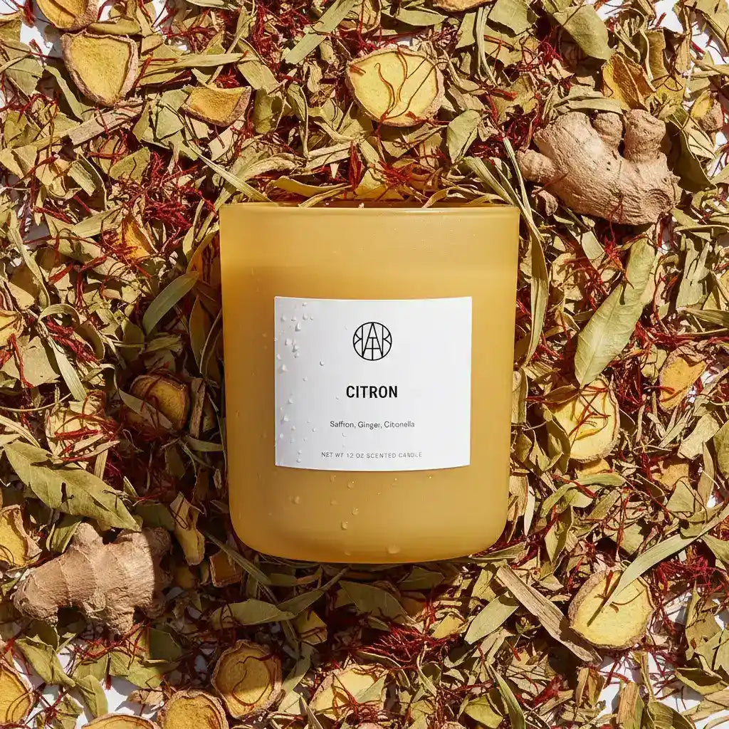 AEMBR citron candle with a simple design, featuring a warm yellow hue and a lit wick, ideal for cozy home decor.