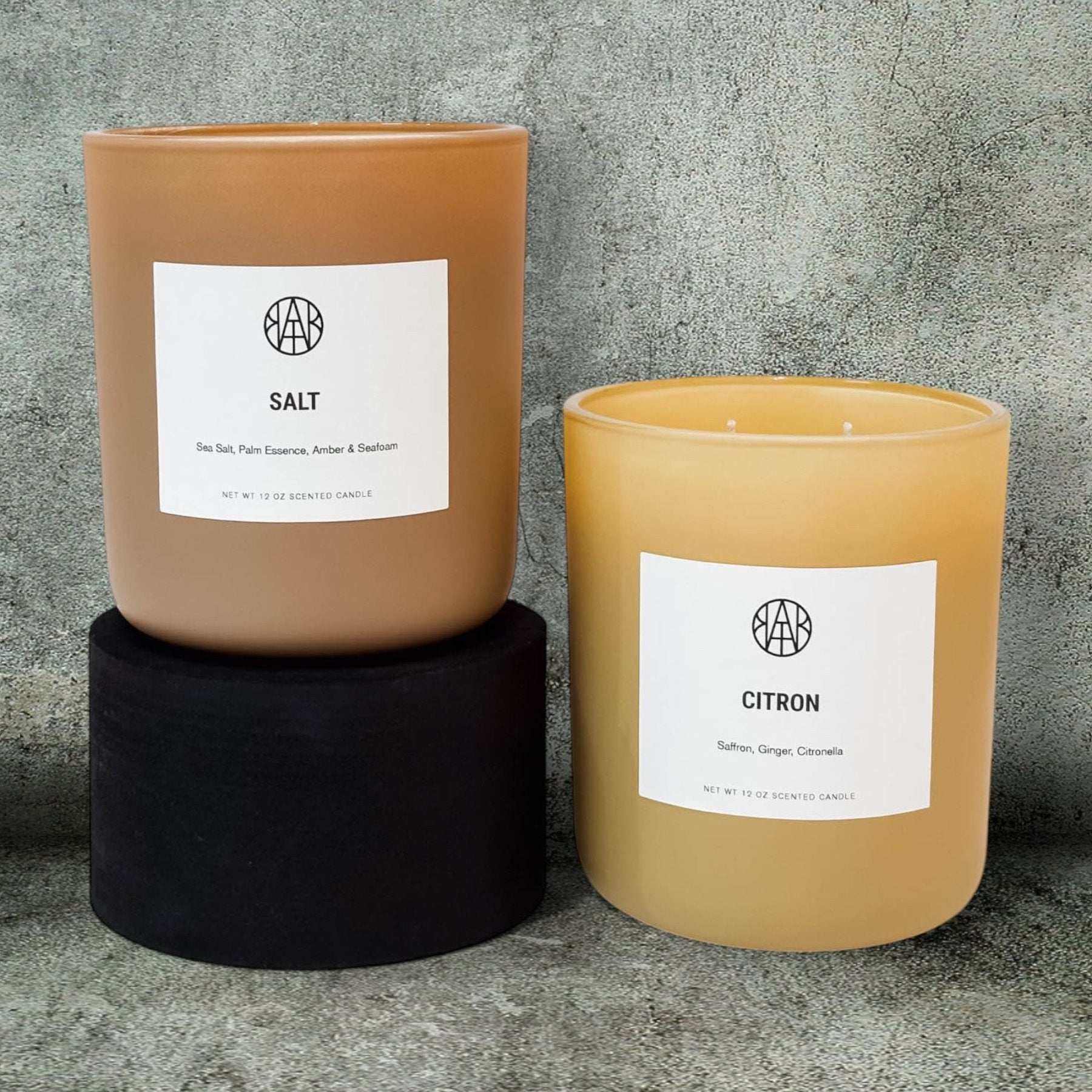 Two non-toxic scented candles labeled Salt and Citron against a stone background.