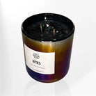 AEMBR Heks Candle, a decorative candle with intricate design, placed on a wooden surface with a warm glow.
