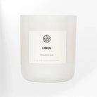 AEMBR Limon Candle with a sleek glass holder, yellow citrus scent, and soft flickering flame, perfect for cozy home decor.