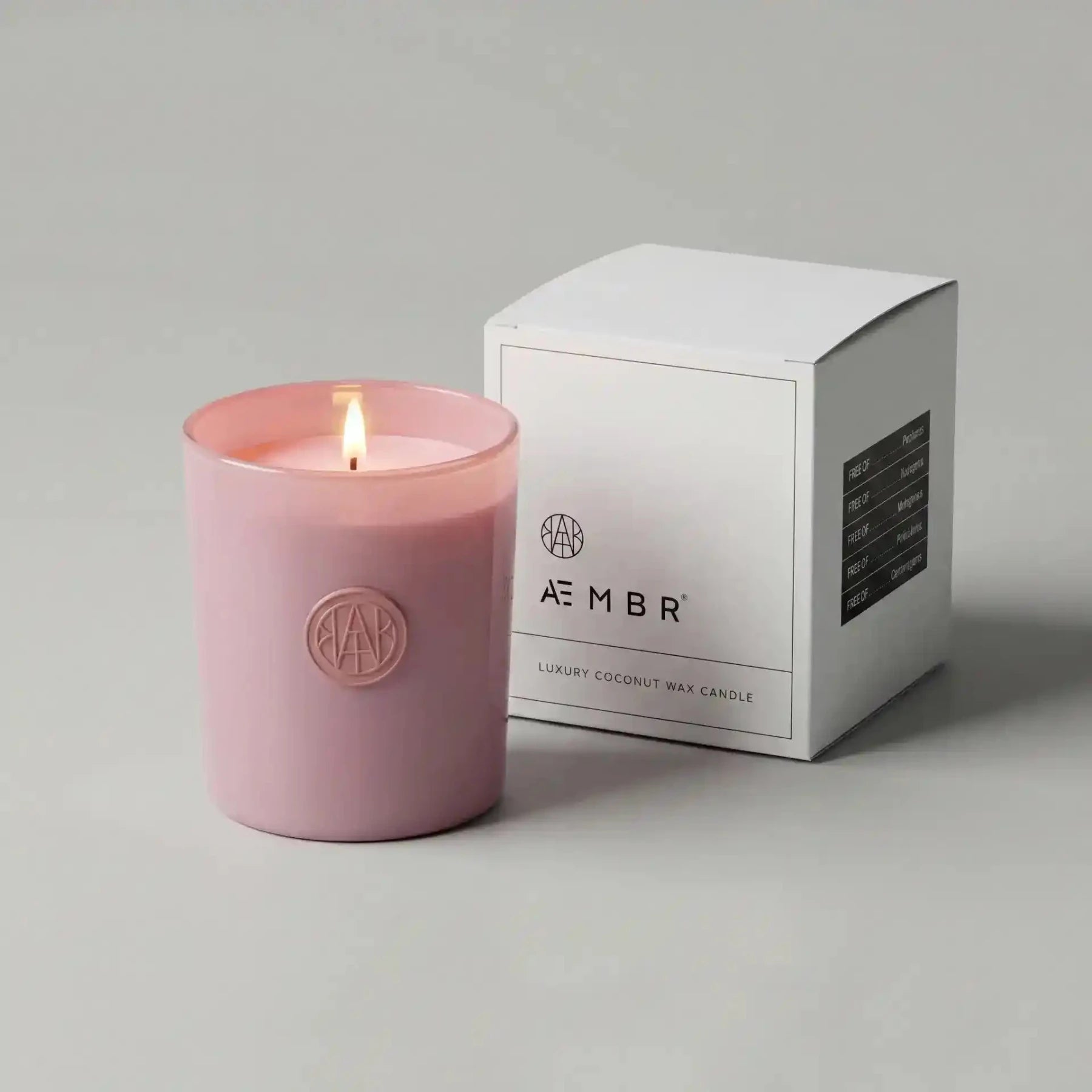 AEMBR Motherlover candle in a decorative glass jar with a lit wick, showcasing warm candlelight and a cozy ambiance.