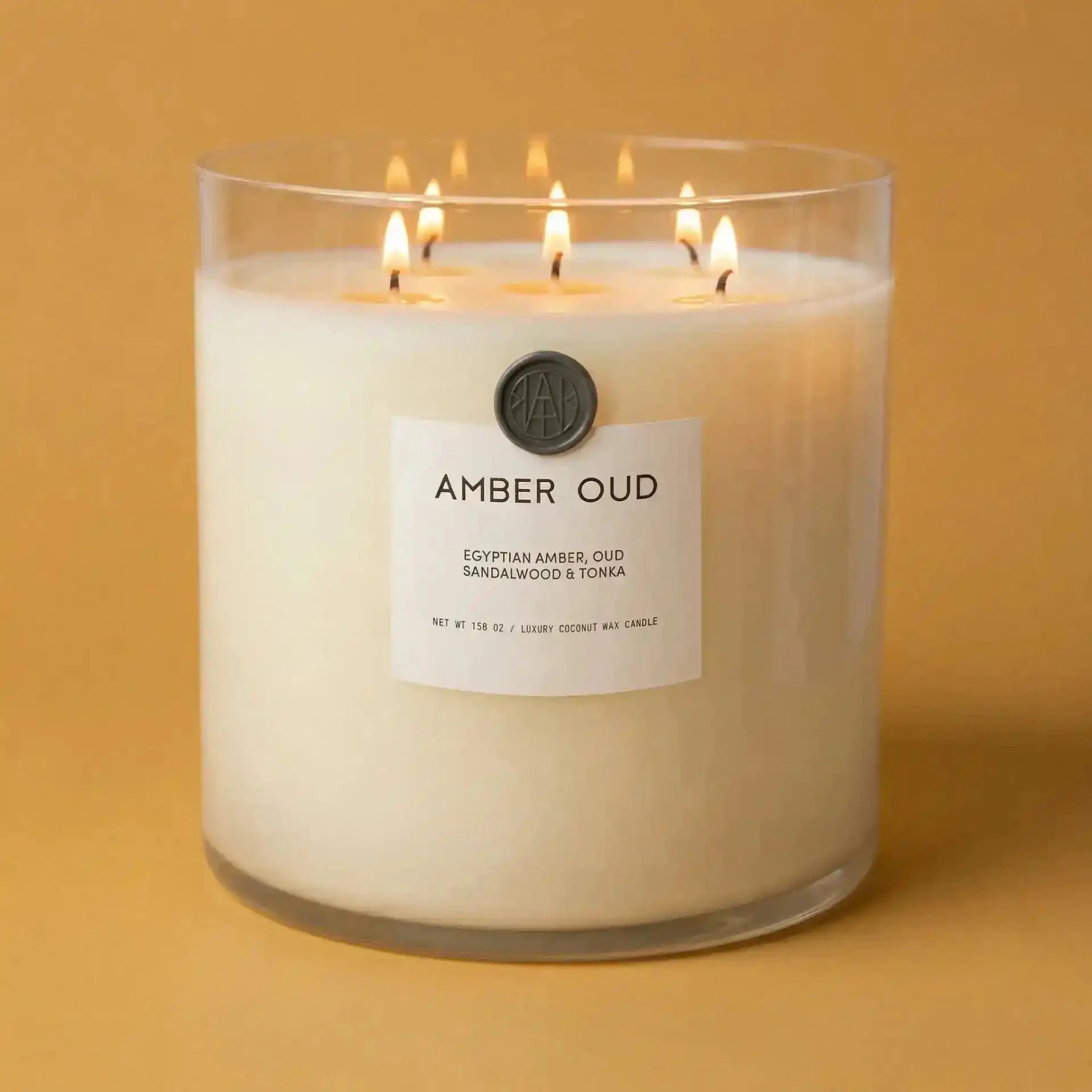 AEMBR The Valkyrie Amber Oud candle with powdery amber and oud scents in a sleek glass container.