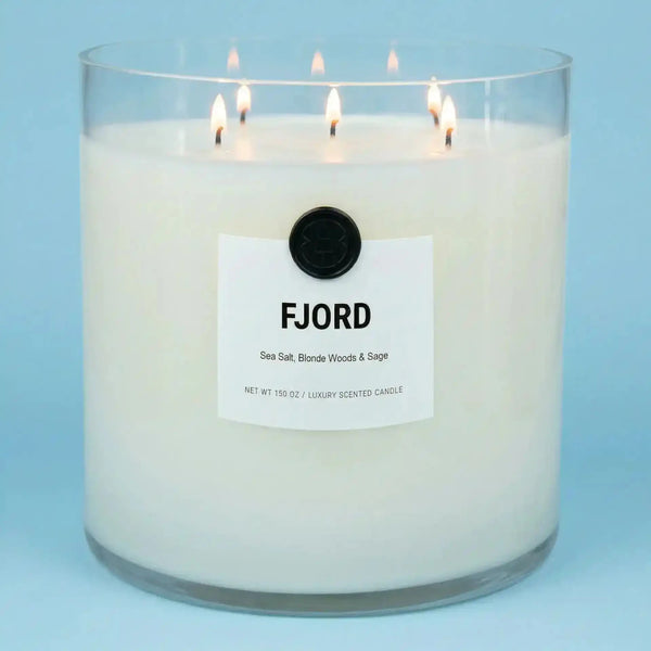 AEMBR The Valkyrie Fjord candle featuring sea salt and sage scent in a sleek container, with a lit wick and flickering flame.