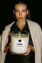 AEMBR The Valkyrie Leaves candle with a natural design, featuring leaves and a sleek candle holder on a neutral background.