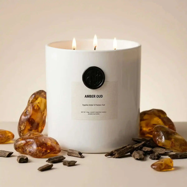 AEMBR The Viking Amber Oud candle with a sleek black container and warm amber-colored wax.