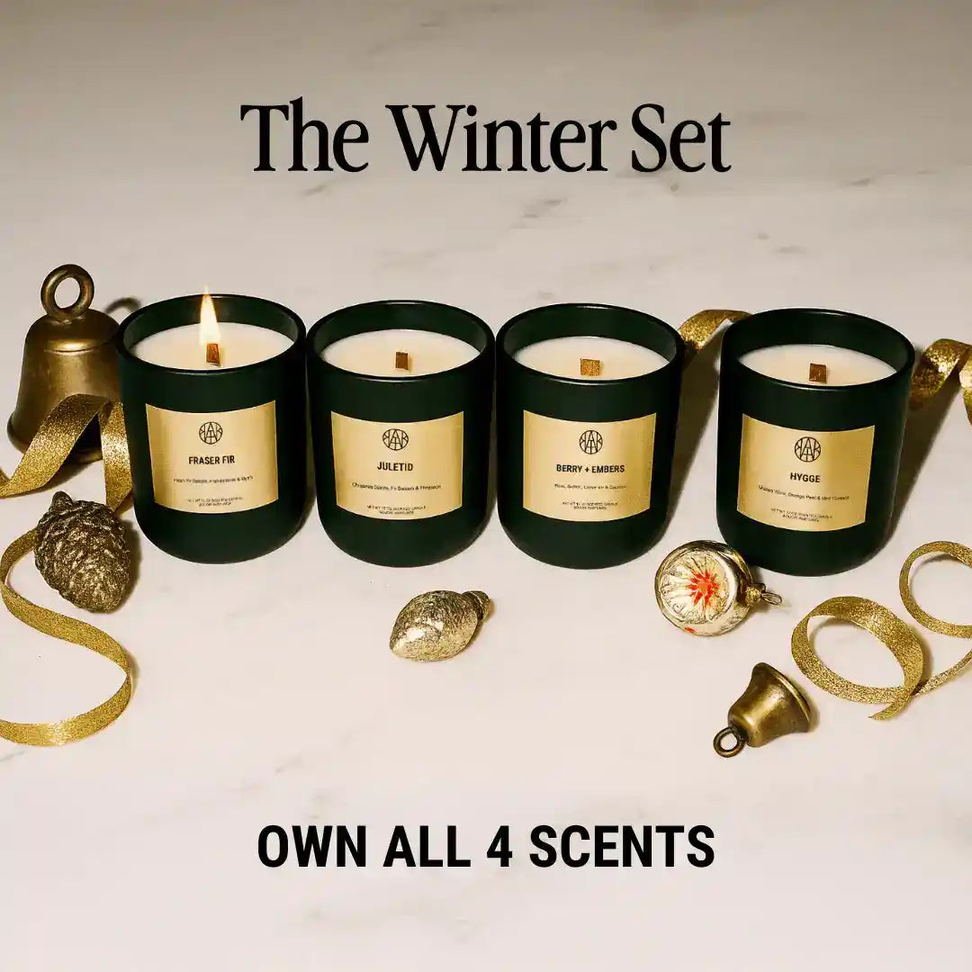 Winter set of four non-toxic candles in dark jars, festive gold decor, marble background