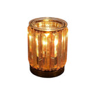 AEMBR golden glass deco candle glowing with warm light, luxury home decor centerpiece