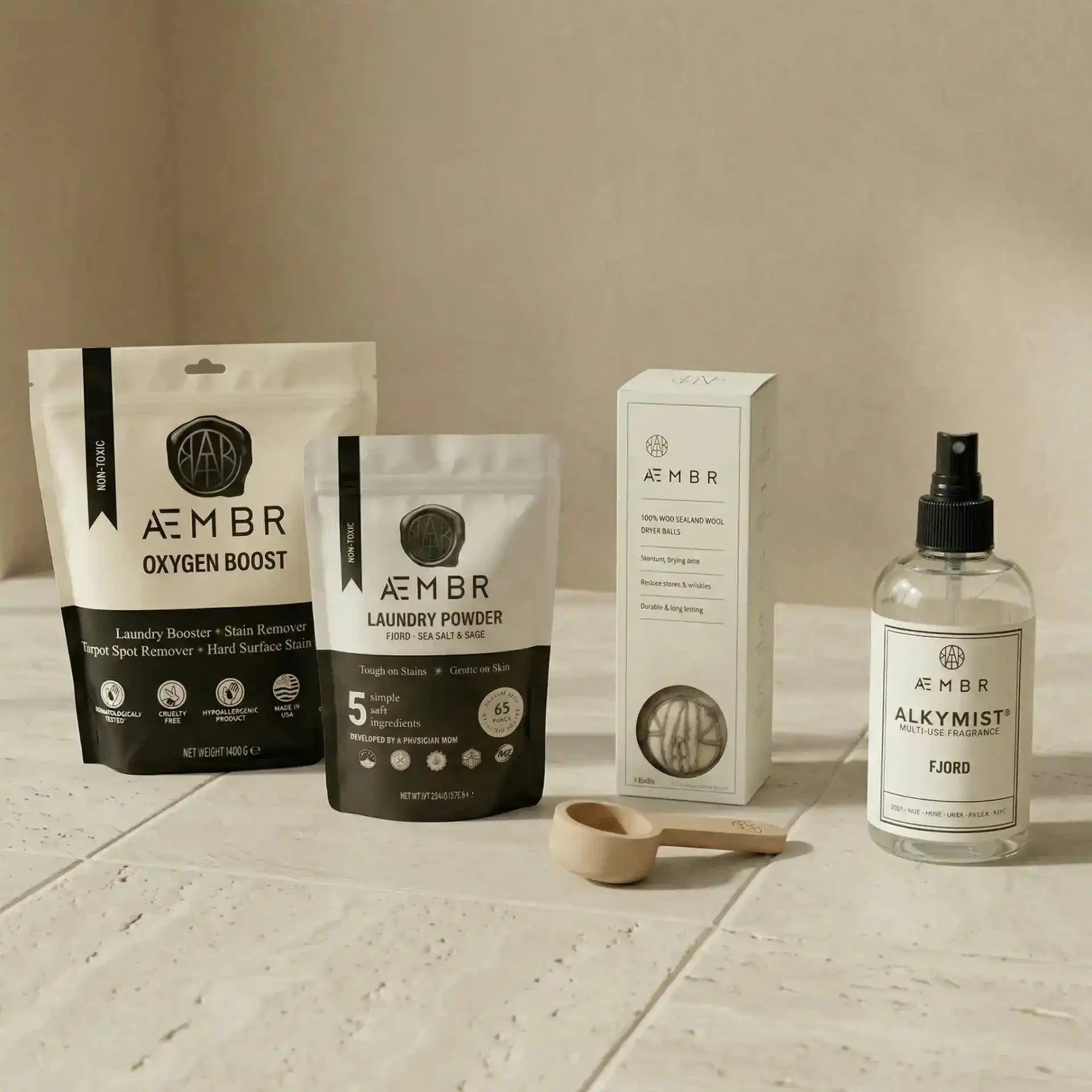AEMBR Ultimate Laundry Kit with detergent, scoop, oxygen boost, dryer balls, and linen spray in a natural laundry bundle set.