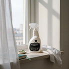 AEMBR non-toxic multi-surface spray cleaner bottle on a windowsill in natural light