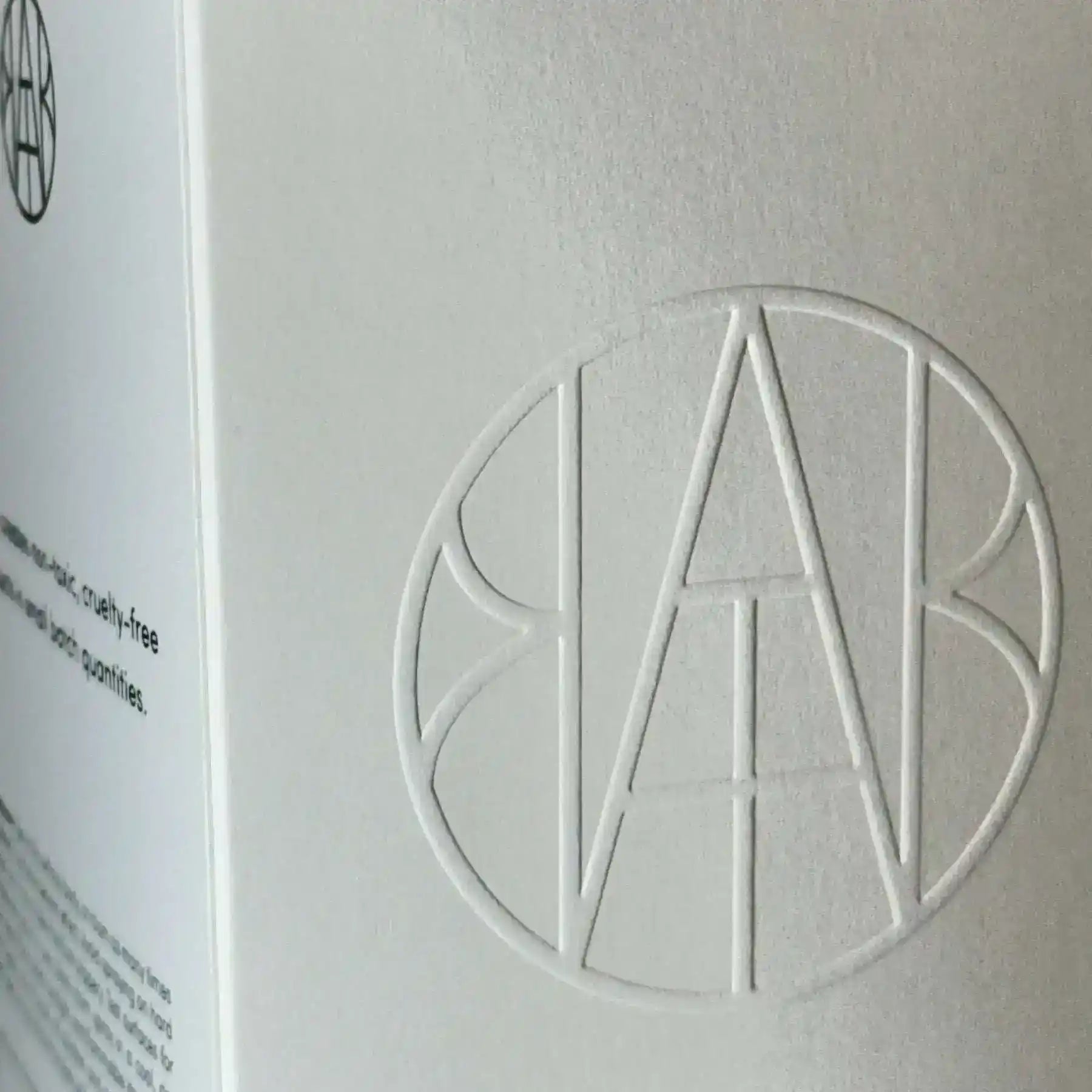 AEMBR ALKYMIST® Luxe Amber Oud multi-use fragrance bottle with elegant amber and gold accents.
