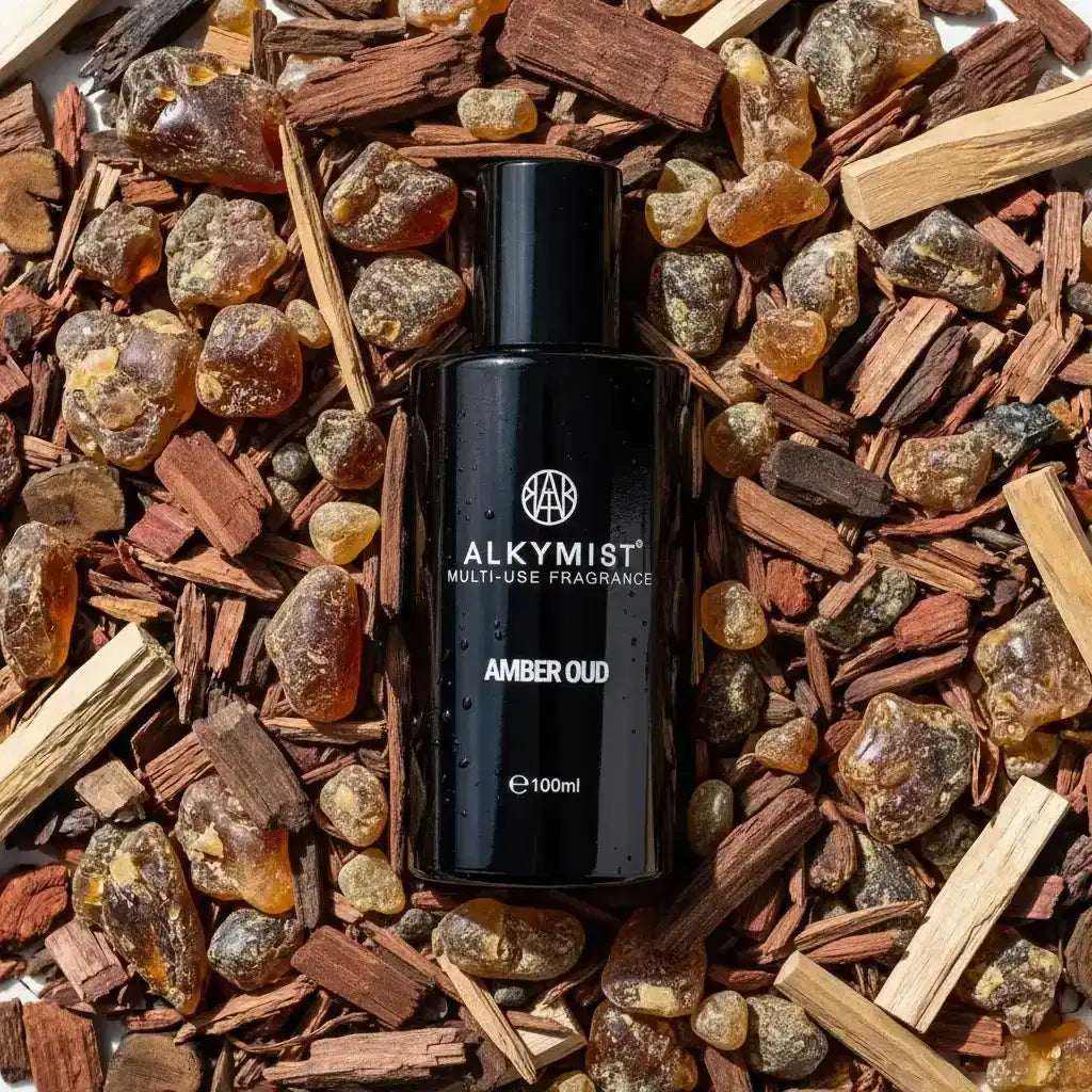 AEMBR ALKYMIST® Luxe Amber Oud multi-use fragrance bottle with elegant label and amber-colored liquid inside.