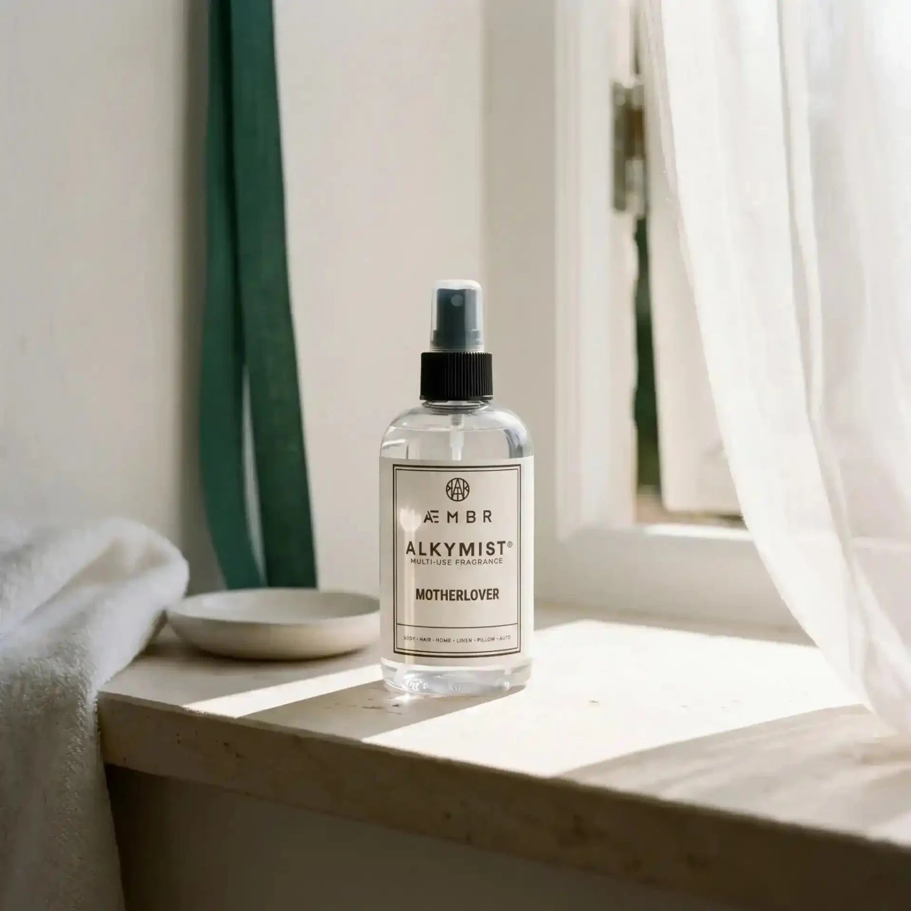 AEMBR Alkymist® Motherlover multi-use room spray with a sleek bottle, designed for freshening indoor spaces with a floral fragrance.