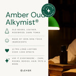 Amber Oud Alkymist non-toxic botanical fragrance bottle on books, lamp, features by AEMBR