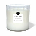 AEMBR Amber Oud luxury non-toxic candle in clear glass jar with white label.