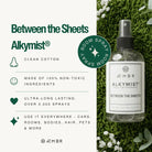 AEMBR Alkymist non-toxic multi-use room spray, clean cotton scent, bottle on grass with flowers