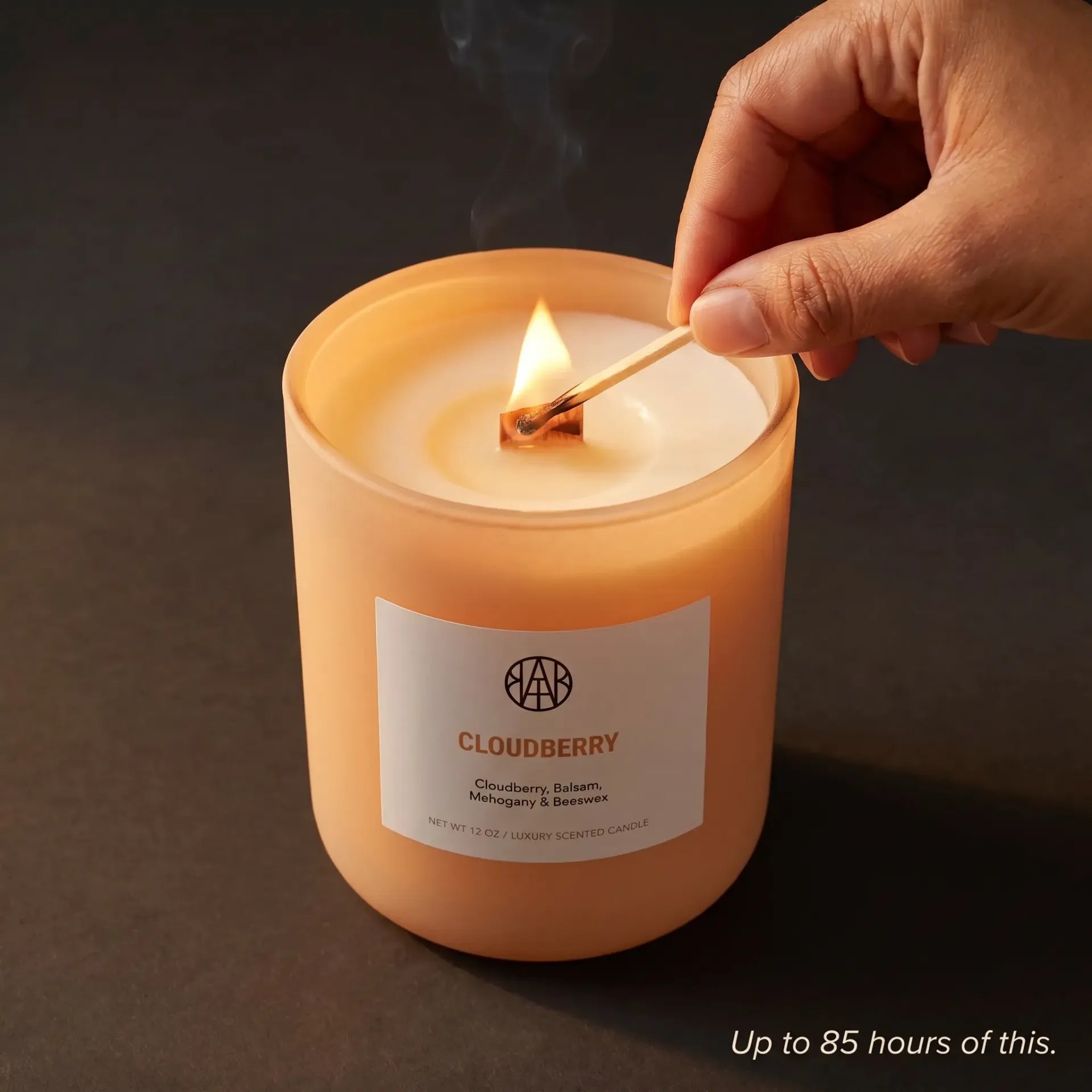 AEMBR Cloudberry Candle with a clear glass holder and a lit wick, showcasing a cozy, aromatic candle for home decor.