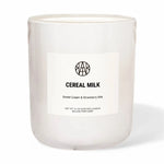 Candle labeled 'Cereal Milk' with a brand logo on a white background