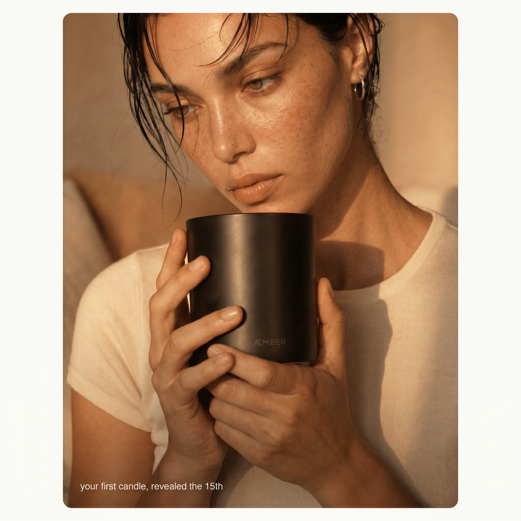 AEMBR Candle of the Month Club — your first candle, revealed the 15th. Model holding AEMBR candle in warm amber light.