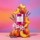 AEMBR pink candle with peaches, flowers, lavender and honey on a pastel gradient background