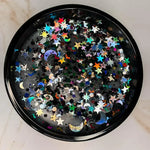 AEMBR non-toxic candle with black wax, decorated with holographic glitter stars and moons.