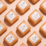 AEMBR Cloudberry non-toxic candles arranged in a stylish grid on a peach background.