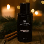 AEMBR Alkymist Fraser Fir multi-use fragrance bottle with cinnamon sticks and candlelight ambiance.