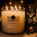 AEMBR Fraser Fir luxury coconut wax candle burning on elegant holiday dinner table with glassware