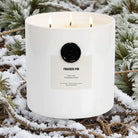 AEMBR Fraser Fir luxury scented candle with three wicks in white jar on snowy pine branches.