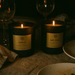 AEMBR non-toxic Fraser Fir and Berry + Embers candles lit on a cozy dinner table.