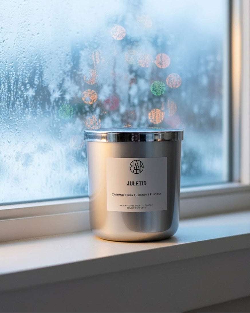Candle with a label on a windowsill with a snowy background